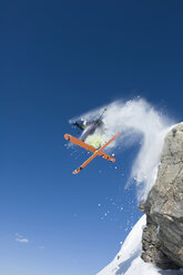 Austria, Man jumping on snow covered arlberg mountain - MIRF00054