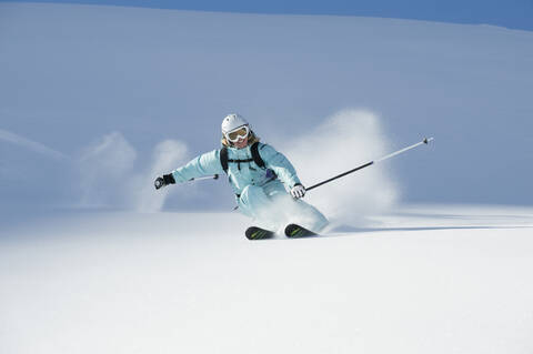 Österreich, Frau beim Skifahren am Arlberg, lächelnd, lizenzfreies Stockfoto