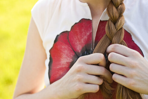 Germany, Bonn, Woman braiding hair, mid section - KJF00079