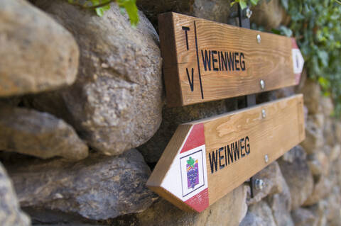 Italien, Südtirol, Text Weinweg auf Holz mit Pfeilzeichen, Nahaufnahme, lizenzfreies Stockfoto
