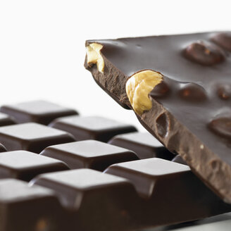 Schokolade mit ganzen Haselnüssen auf weißem Hintergrund - SRSF00094