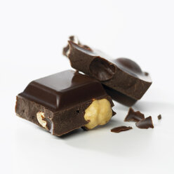 Chocolate with whole hazelnuts on white background - SRSF00093