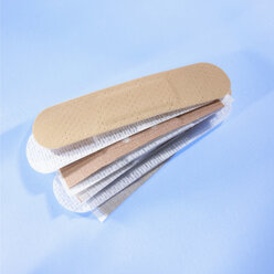 Stack of band-aids on blue background - SRSF00092