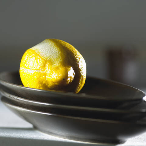 Lemon on stack of plates, close-up stock photo