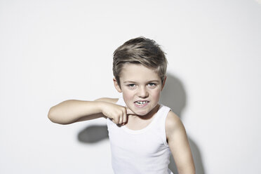 Boy (8-9) standing against white background, gesturing - PDF00020