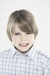 Junge (8-9), der die Zähne zusammenbeißt, Nahaufnahme, Porträt - PDF00013