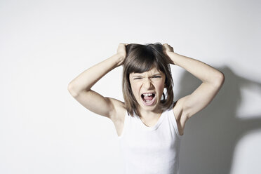 Girl (10-11) standing against white background, pulling hair - PDF00008