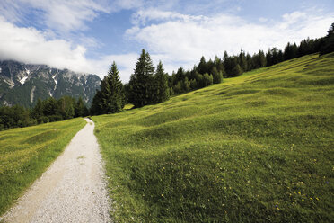 Deutschland, Bayern, Blick auf eine Straße durch eine ländliche Landschaft im Karwendelgebirge - 12710CS-U