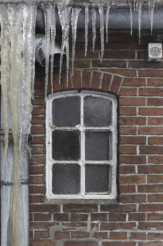 Deutschland, Hamburg, Ansicht eines Hausfensters mit Eiszapfen im Vordergrund, lizenzfreies Stockfoto