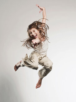 Girl (10-11) jumping and smiling, portrait stock photo
