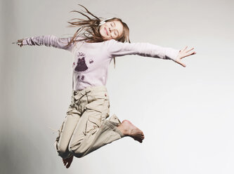 Mädchen (10-11) hört Musik und springt - FMKF00117