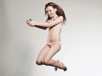 Girl (10-11) jumping and smiling, portrait stock photo