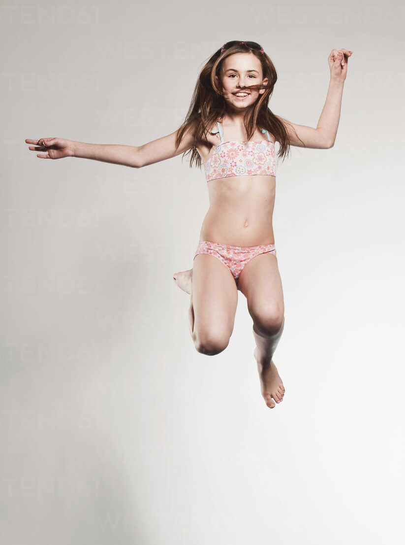 https://us.images.westend61.de/0000080150pw/girl-10-11-jumping-and-smiling-portrait-FMKF00106.jpg