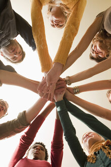 Germany, Leipzig, Group of university students putting hands together, low angle view - BABF00636