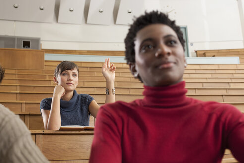 Germany, Leipzig, University student raising hand in classroom - BABF00625