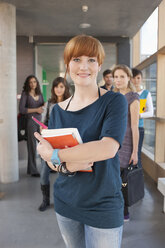 Germany, Leipzig, Women smiling, students standing in background - BABF00561