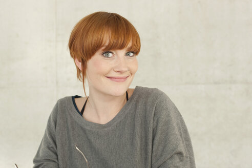 Germany, Leipzig, Young woman standing, smiling, portrait - BABF00555