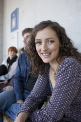 Deutschland, Leipzig, Frau lächelnd mit Studenten im Hintergrund - BABF00524