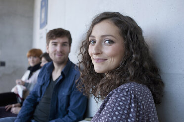 Deutschland, Leipzig, Mann und Frau lächelnd, Studenten im Hintergrund - BABF00523