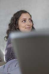 Germany, Leipzig, Young woman looking away, smiling - BABF00505