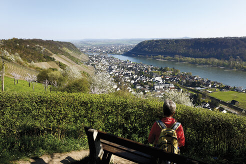 Deutschland, Rheinland-Pfalz, Neuwied, Frau sitzt auf einer Bank und schaut auf die Aussicht - 13028CS-U