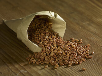 Fenugreek seeds spilling on wooden surface - SRSF00201