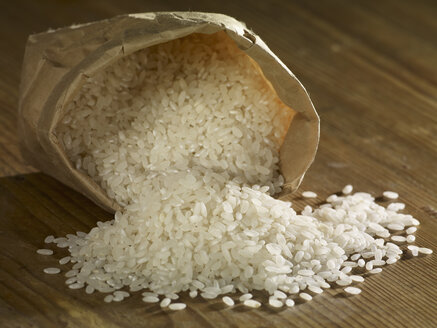 Runder Mais-Reis, der auf einer Holzoberfläche verschüttet wird - SRSF00199