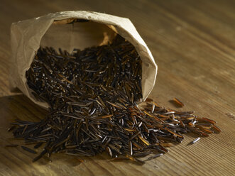 Canadian wild rice spilling on wooden surface - SRSF00195