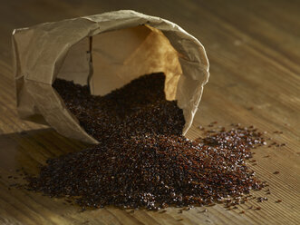 Psyllium seeds spilling on wooden surface - SRSF00193