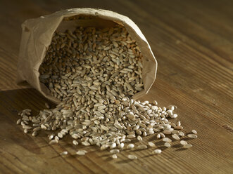 Rye grains spilling on wooden surface - SRSF00177