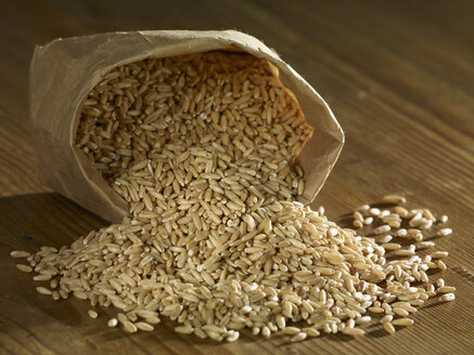 Oat grain spilling on wooden surface - SRSF00176