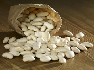 Large white beans spilled on wooden surface - SRSF00158