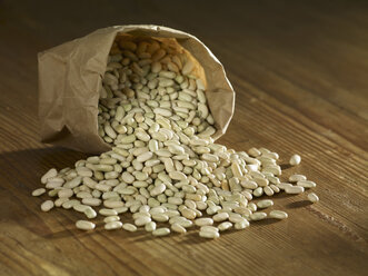 Flageolet beans spilled on wooden surface - SRSF00154