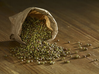 Brown mung beans spilled on wooden surface - SRSF00149