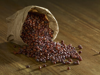 Red mung beans spilled on wooden surface - SRSF00148