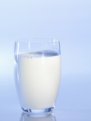Glass of milk against blue background, close-up - SRSF00131