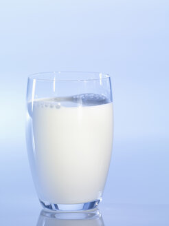 Glas Milch vor blauem Hintergrund, Nahaufnahme - SRSF00131