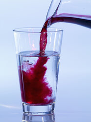Einschenken von Johannisbeersaft in ein Glas Wasser, Nahaufnahme - SRSF00124