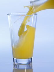 Einschenken von Orangensaft in ein Glas, Nahaufnahme - SRSF00118