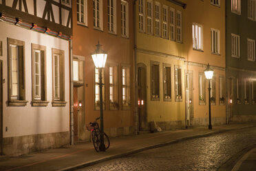 Germany, Hannover, Kreuz Street, City street with row of houses at night - WDF00700