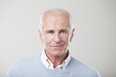 Man standing against gray background, smiling, portrait - CLF00916