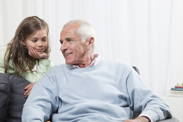 Enkelin (6-7) mit dem Kopf in der Hand hört dem Großvater zu - CLF00905