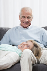 Mann mit Frau auf dem Schoß sitzend, lächelnd - CLF00889