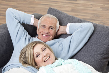 Älteres Paar auf Couch liegend, lächelnd, Porträt - CLF00883