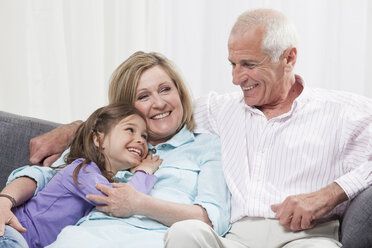 Granddaughter (6-7) and grandparents enjoying, smiling - CLF00876