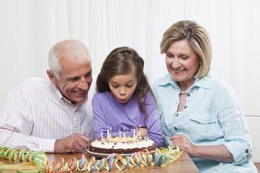 Granddaughter (6-7) and grandparents celebrating birthday - CLF00862