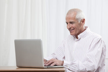 Man using laptop, smiling - CLF00843