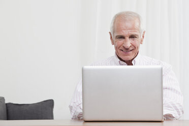 Man using laptop, smiling - CLF00842