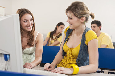 Deutschland, Emmering, Teenager-Mädchen und Frau lächelnd mit Studenten im Hintergrund - RNF00360