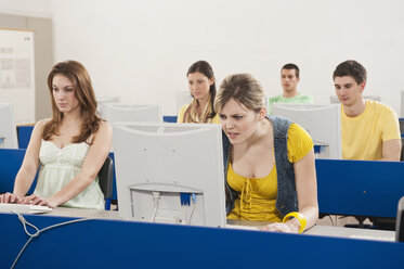 Deutschland, Emmering, Studenten benutzen Computer im Computerraum - RNF00347